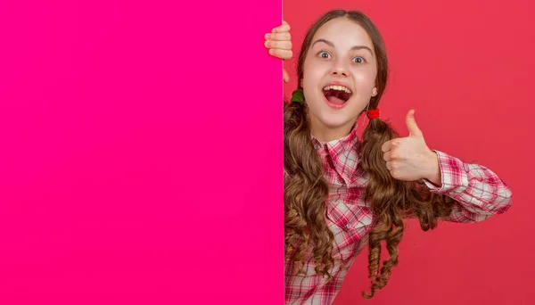 Verbaasd Tiener Meisje Achter Blanco Roze Papier Met Kopieerruimte Voor — Stockfoto