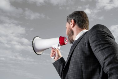 businessman shout loud in loudspeaker on sky background.