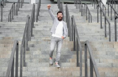 bearded guy walk downstairs. full length of successful guy with beard. hipster guy outdoor at stairs.