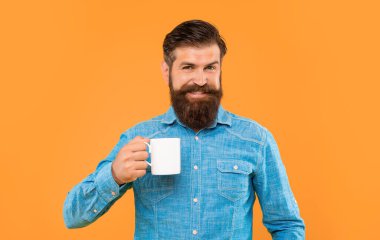 Kafkasyalı mutlu bir adam elinde çay fincanı, sarı arka plan.