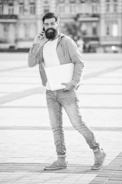 Telefondaki serbest iletişim konuşmalarıyla traşsız bir adam. Dizüstü bilgisayarında serbest iletişimi olan bir adam. Dışarıda serbest çalışan bir adam var. Serbest iletişimi olan bir adam..