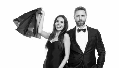 Arka planda neşeli bir alışveriş çifti. Alışveriş torbalı bir çiftin fotoğrafı. Alışveriş çifti beyazda izole edilmiş. Stüdyodaki alışveriş çifti.