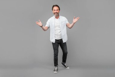 Kolları açık, el kol hareketleri yapan mutlu kıdemli adam, hoş geldin..