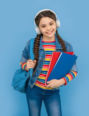 Mavi sesli kurs dinleyen mutlu genç kız. Kulaklıkla sesli kitap dinleyen bir genç. Dinleme becerileri. Okul eğitimi.