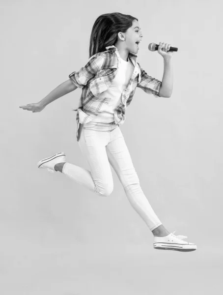 10代の少女カラオケ歌手のマイク付き 黄色に隔離された10代の少女カラオケ歌手 スタジオで10代の少女カラオケ歌手 10代の少女カラオケ歌手 — ストック写真
