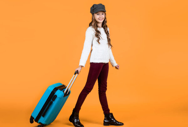 on the way. ready for vacation trip. adventure. happy teen girl with bag. spring kid fashion style. child with travel suitcase wearing trendy beret. concept of travelling. childhood happiness.