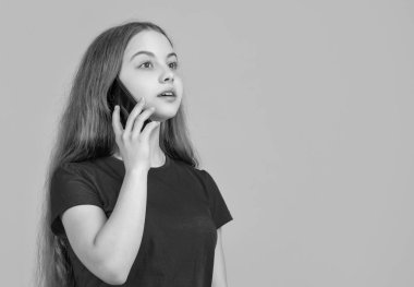 Çocuk sarı arka planda akıllı telefondan konuşuyor..