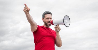 Kırmızı gömlekli adam arka planda hoparlörden bağır. ajitasyon.