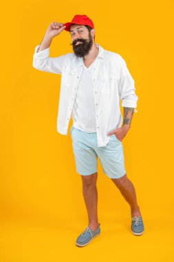 Sarıda izole edilmiş modaya uygun beyaz adam. Stüdyoda şık bir beyaz adam var. Arka planda şık bir beyaz adam. Beyaz adamın yaz modası giymiş şık bir fotoğrafı..