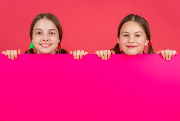 広告のためのコピースペースを持つ空白のピンクの紙の後ろに笑顔の子供 — ストック写真