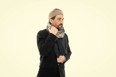 Sıcak kıyafetler ve şapka giyen bir adamın stüdyo fotoğrafı. Kış modası ve kalın giysiler. Kışın kalın giysiler içinde olgun bir adam. Erkek kışın beyaz arka planda kalın giysiler giyer..