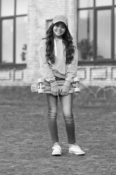 少年女子滑板与滑板的童年 少女在户外滑冰的童年 少年女子滑冰运动员的童年在外面 少年女子滑冰运动员在街上的童年 — 图库照片