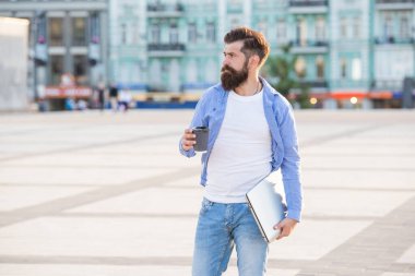 Açık havada serbest iletişimde olan bir adam, uzay afişini kopyalayın. Elinde kahve tutan serbest çalışan bir adam. Dizüstü bilgisayarında serbest iletişimi olan bir adam. Dışarıda serbest çalışan bir adam var..