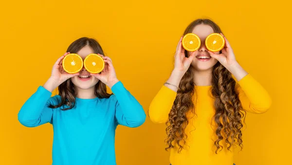 Αστεία Έφηβα Κορίτσια Κατέχουν Πορτοκαλί Φρούτα Κίτρινο Φόντο — Φωτογραφία Αρχείου