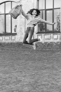 school girl jump childhood outside, knowledge day. school girl jump childhood at the street. photo of school girl jump childhood with backpack. school girl childhood jump outdoor.