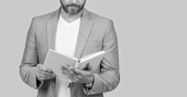 cropped studio shot of businessman holding planner. photo of businessman hold planner. businessman with planner isolated on yellow background. businessman with planner in jacket.