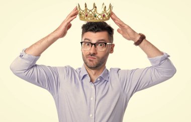 İş adamı başarılı olmak için taç giyer. Taçlı iş adamının stüdyo fotoğrafı. Kafası karışmış iş adamı beyaz arka planda izole edilmiş. İş adamına ödül.