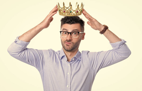 бизнесмен носит корону для успешного бизнеса. студийный кадр бизнесмена в короне. Озадаченный бизнесмен в короне изолирован на белом фоне. Корона награда для бизнесмена.