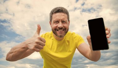 Mutlu adam akıllı telefon ekranını kopyalama alanı ile sunuyor.