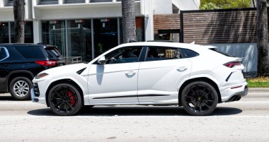 Miami Beach, Florida USA - April 15, 2021: 2019 white Giallo Auge Lamborghini Urus, side view.