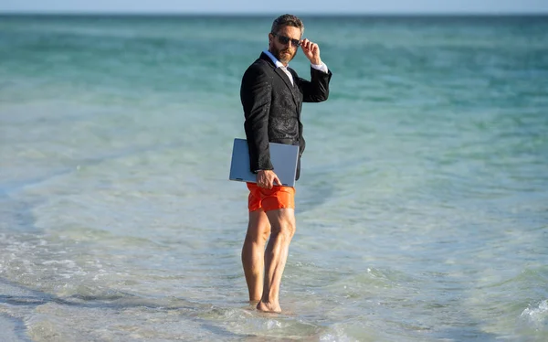 stock image Business man dreams on summer in sea. Summer business. Freelancer business man on summer vacation. Summer weekend and remote freelance work. business man with laptop. Relaxation awaits.