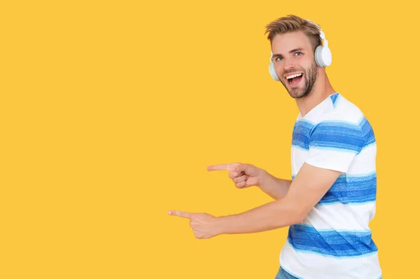 Estudy Άνθρωπος Στα Ακουστικά Δείχνοντας Δάχτυλο Κίτρινο Πανό Φόντο Χώρο — Φωτογραφία Αρχείου