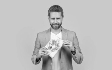 Kutu tutan neşeli adamın fotoğrafı. Adam şu anki kutuyu sarı arkaplanda izole olarak tutuyor. Adam hediye kutusunu stüdyoda tutuyor. Tatil için hediye kutusu olan adam..