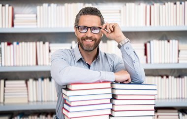 Okul kütüphanesinde üniversite öğretmeni. Öğretmenler gününde bilgi ve eğitim alan kitapları okumak için sınava hazırlanıyor..