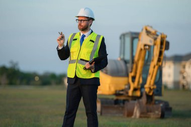 İnşaat alanındaki amir. Dışarıdaki denetçi. Kask takan amir. Yönetici adamın fotoğrafı.