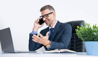 Ofiste telefonda bilgisayarla konuşan mutlu iş adamı..