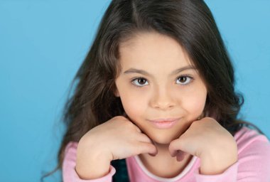 Mavi üzerine izole edilmiş neşeli genç kız portresi. Stüdyoda genç bir kızın portresi. Arka planda genç bir kızın portresi. Genç bir kızın fotoğrafı..