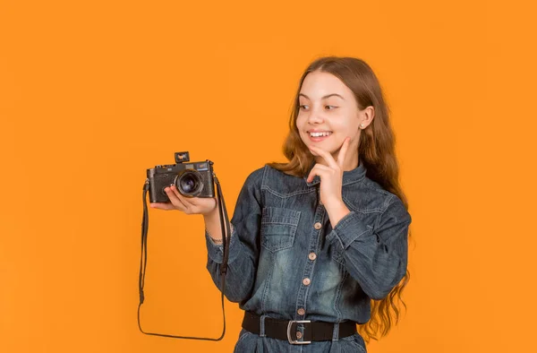stock image Interested in photography. Happy child looking at photo camera on hand. Girl photographer with camera.