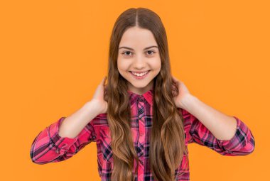 portrait of teen girl isolated on yellow. teen girl in studio. teen girl on background. photo of teen girl with long hair wearing checkered shirt.