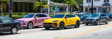 Miami Beach, Florida USA - April 15, 2021: Bentley Bentayga v8 2015 and Lamborghini Urus on road.