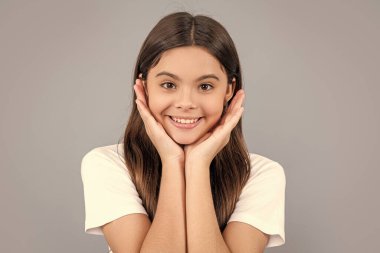 portrait of teen girl with long hair wearing tshirt. teen girl isolated on grey. teen girl in studio. teen girl on background.