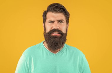 Bıyıklı şaşkın sakallı adamın fotoğrafı. Sakallı adam sarıda izole edilmiş. Stüdyodaki sakallı adam. Arka planda sakallı adam.