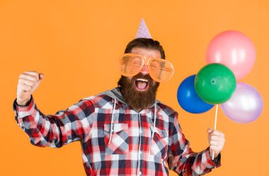 Mutluluk dolu. Şık erkek doğum gününde eğleniyor. Sakallı adam bayramı kutluyor. Yıldönümü. Ona sürpriz yapacağım. Yetenekli bir etkinlik yöneticisi. Kareli tişörtlü ve balonlu olgun bir adam..