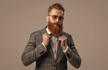 Sakallı, karizmatik smokinli bir adamın resmi. Smokinli resmi adam Griler 'de izole edilmiş. Smokin stüdyosundaki resmi adam. Smokin resmi adam arka planda.