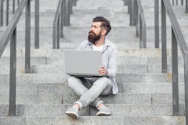 Hayalperest adamın merdivenlerde çevrimiçi video bağlantısı var. Adamın bilgisayarında çevrimiçi video bağlantısı var. Adamın dışarıda online video iletişimi var. Adamın dışarıda internet bağlantısı var..
