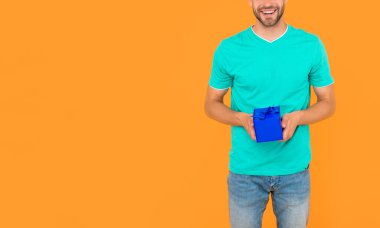 Kırpılmış adam hediye kutusunu sarı arka planda tutuyor fotokopi alanı, boks günü.