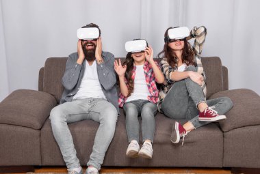 Sanal gerçeklik ailesi. Mutlu ebeveynler ve kızlar modern teknolojiyi kullanıyorlar. Anne, baba ve kızı. Dijital gelecek ve yenilik. Modern hayat. Baba, anne ve çocuk kablosuz internet gözlüğü..