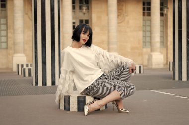 Zarif esmer kadın model oturuyor. Açık havada zarif esmer kadın. Dışarıdaki zarif esmer kadın. Sokaktaki zarif esmer kadın..