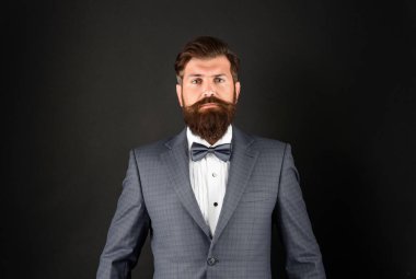 serious man in tuxedo bowtie. butler in formalwear on black background. male formal fashion.