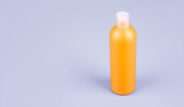 Kozmetik ürünleri sunuyorum. Markasız şampuan reklamı. Saç kremi ya da vücut losyonu. Günlük alışkanlık ve kişisel bakım. Mavi arka planda cilt güzellik kozmetiği. Boşluğu kopyala.