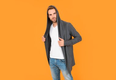 Kendine güvenen ve yakışıklı, tıraşsız adam. Erkek modası. Erkek güzelliği. Tüylü adam. Sarı arka planda sakallı genç bir adam. saç ve sakal bakımı.