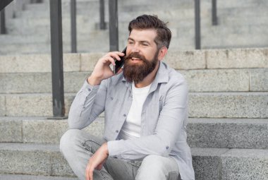 İyi ki dışarıda akıllı telefonlar var. Adamın dışarıda akıllı telefon görüşmesi var. Adamın sokakta akıllı telefonları var. Fotoğrafta akıllı telefon var..