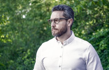 Gözlüklü yakışıklı profesyonel arka plana bakıyor, boşluğu kopyala.