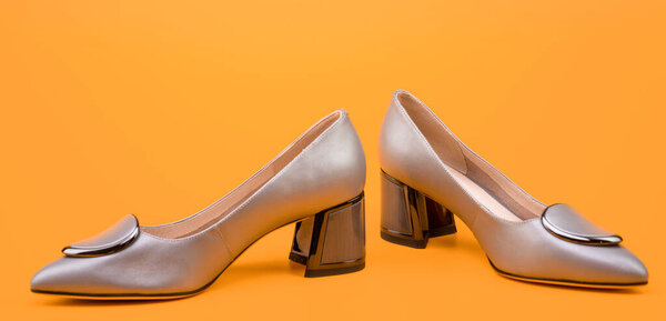 leather beige shoes on yellow background, new pair.