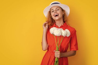 Anneler günü çiçekli kız sarıya izole edilmiş, kopyalama alanı. Stüdyoda anneler günü çiçekleri olan kız. Arka planda anneler günü çiçekleri olan kız. Anneler Günü 'nde kasımpatı çiçekli bir kızın fotoğrafı.