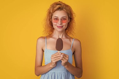 Dondurmalı gülümseyen kadın sarıya izole edilmiş. Stüdyoda dondurmalı kadın. Arkasında dondurma olan bir kadın. Yazın dondurmalı kadın fotoğrafı..